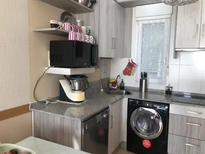 a kitchen with a microwave and a washing machine at O Xuncal in Barreiros