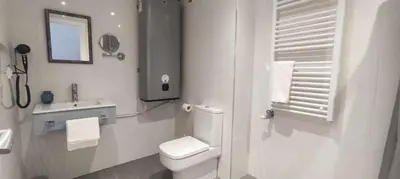 a white bathroom with a toilet and a sink at Estación de Montaña Manzaneda, Ciudad de Lugo, 114 in Ourense