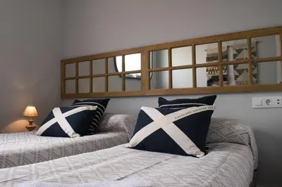 a bedroom with two beds and a mirror on the wall at Estación de Montaña Manzaneda, Ciudad de Lugo, 114 in Ourense