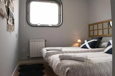 two beds in a small room with a window at Estación de Montaña Manzaneda, Ciudad de Lugo, 114 in Ourense