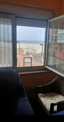 a room with a couch and a window with a view of a beach at FOZ PLAYA RAPADOIRA in Foz