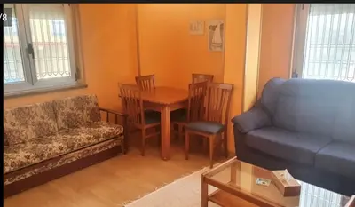 a living room with a table and chairs and a couch at FOZ PLAYA RAPADOIRA in Foz
