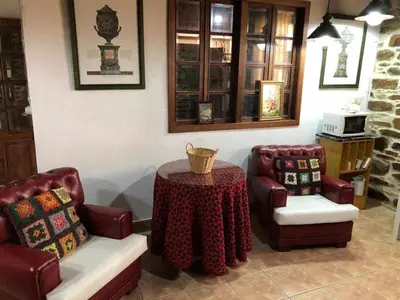 a living room with a table and two chairs at Casa do Hiebra Alojamiento Rural Ribeira Sacra in Castroncelos