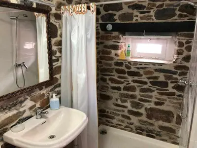a bathroom with a sink and a stone wall at Casa do Hiebra Alojamiento Rural Ribeira Sacra in Castroncelos