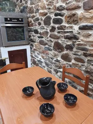 a wooden table with four black bowls on it at Casa do Hiebra Alojamiento Rural Ribeira Sacra in Castroncelos