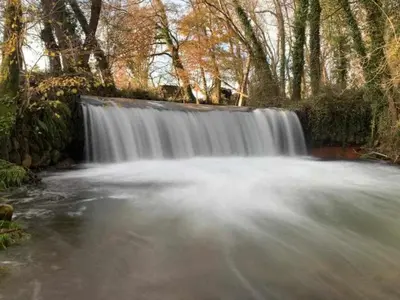 a waterfall in the middle of a river at Casa do Hiebra Alojamiento Rural Ribeira Sacra in Castroncelos