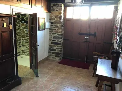 a room with two doors and a stone wall at Casa do Hiebra Alojamiento Rural Ribeira Sacra in Castroncelos