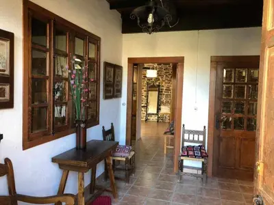 a room with a table and chairs and a hallway at Casa do Hiebra Alojamiento Rural Ribeira Sacra in Castroncelos