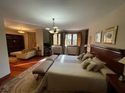 a large bedroom with a large bed and a living room at Casa rural en entorno privilegiado in Valongo