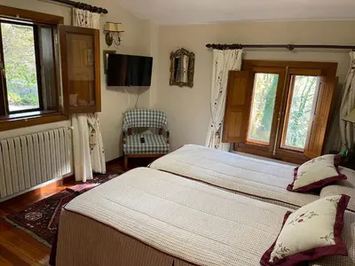 a bedroom with two beds and a flat screen tv at Casa rural en entorno privilegiado in Valongo