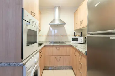 a kitchen with wooden cabinets and a stainless steel refrigerator at ***** Solaina das Burgas ***** en el Casco Viejo in Ourense