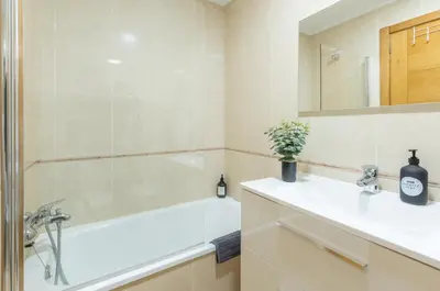 a bathroom with a white tub and a sink and a bath tubermott at ***** Solaina das Burgas ***** en el Casco Viejo in Ourense