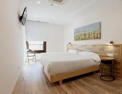 a bedroom with a bed and a table and a chair at Casa Miño in Ourense