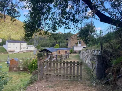 a wooden fence in front of a village with houses at A Casa das Augas in Mondoñedo
