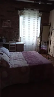 a bedroom with a large bed and a window at A Casa das Augas in Mondoñedo