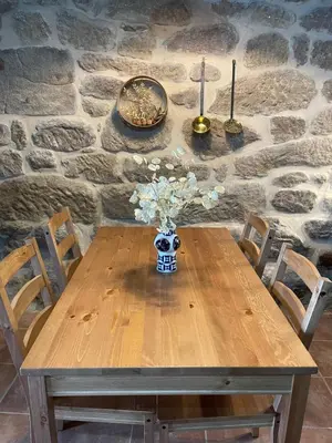 a wooden table with a vase of flowers on it at Casa Anduriña in Ourense