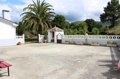 a white fence with a gate and a building at Casa Arquella in Cartavio