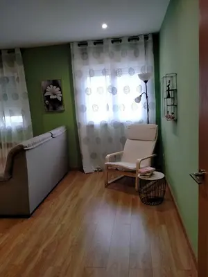 a living room with a chair and a couch and a window at Casilla in Sarria