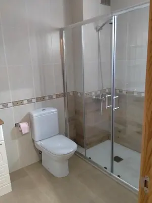 a bathroom with a toilet and a glass shower at Casilla in Sarria