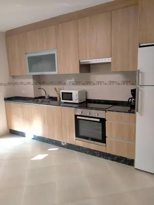 a kitchen with wooden cabinets and a white refrigerator at Casilla in Sarria
