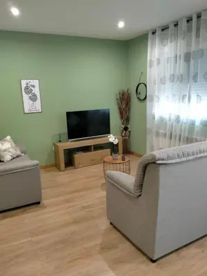 a living room with two couches and a flat screen tv at Casilla in Sarria