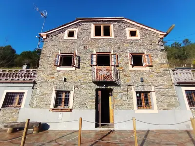 an old stone building with a balcony at Mirador del Navia in Serandinas