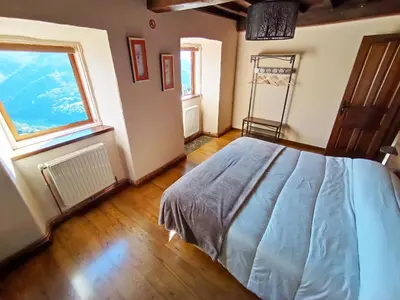 a bedroom with a bed and a large window at Mirador del Navia in Serandinas