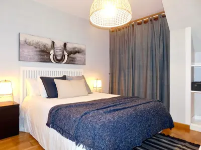 a bedroom with a bed and a chandelier at Rías Altas Home Sada in Sada