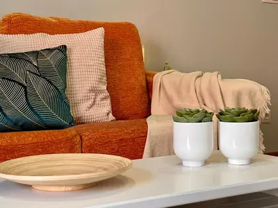 two white vases sitting on a table with a couch at Rías Altas Home Sada in Sada