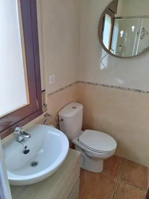 a bathroom with a toilet and a sink and a mirror at O Pedregal in Burela de Cabo