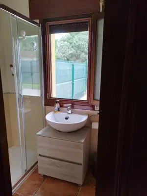 a bathroom with a sink and a window and a shower at O Pedregal in Burela de Cabo