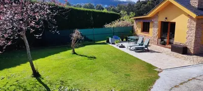 a small yard with a bench in the grass at O Pedregal in Burela de Cabo