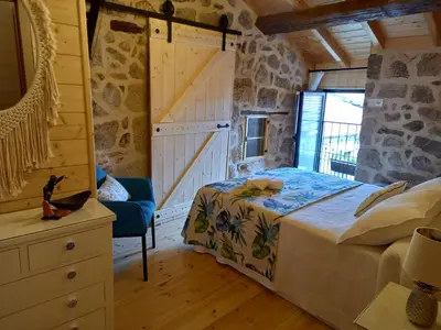 a bedroom with a bed and a chair in a room at Rincón del Viso in Ourense