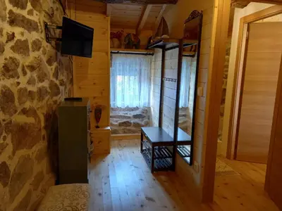 a room with a table and a television in a log cabin at Rincón del Viso in Ourense