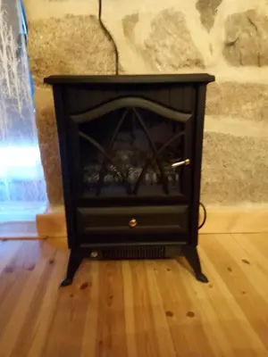 a black fireplace in a room with a wooden floor at Rincón del Viso in Ourense