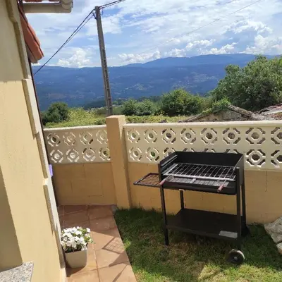 a barbecue grill on a fence with a view of mountains at Casa Costal in Mondariz