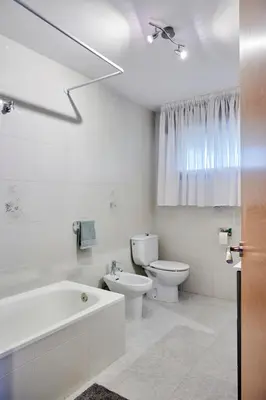a white bathroom with a tub and a toilet at Casa Costal in Mondariz