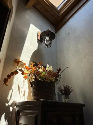a basket of flowers sitting on a table with a light at La CasuKa VUT Fabero in Fabero