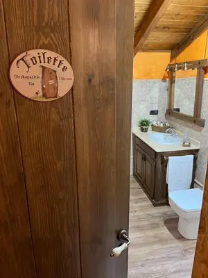 a bathroom with a toilet and a sink at La CasuKa VUT Fabero in Fabero