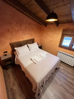 a bedroom with a bed with two towels on it at La CasuKa VUT Fabero in Fabero