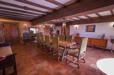 a dining room with a wooden table and chairs at Pazo del siglo XVII en el corazón de Galicia in Lalín