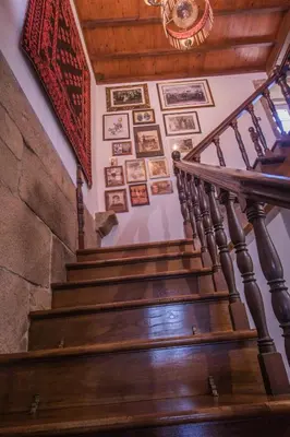 a staircase with pictures on the wall and a rug at Pazo del siglo XVII en el corazón de Galicia in Lalín