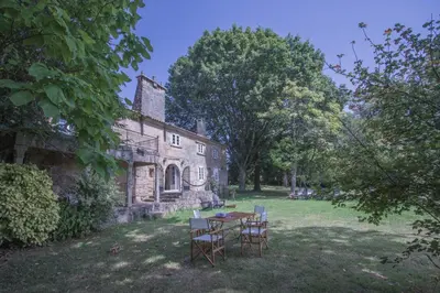 a table and chairs in front of a stone house at Pazo del siglo XVII en el corazón de Galicia in Lalín