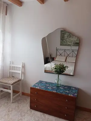 a bedroom with a mirror and a dresser and a chair at La Favorita in Pontevedra