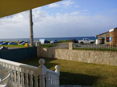 a balcony with a white fence and a view of the ocean at Casa Aroa in Barreiros