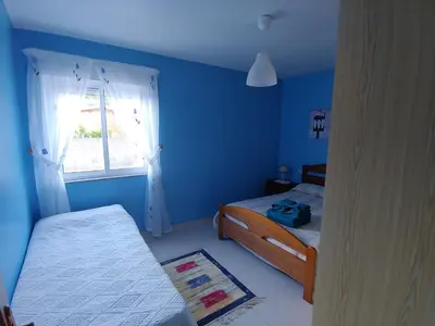 a blue room with two beds and a window at Casa Aroa in Barreiros