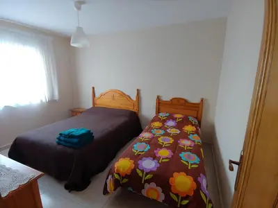 a bedroom with two beds and a bedspread with flowers at Casa Aroa in Barreiros