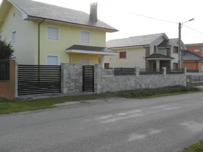 a house with a retaining wall and a fence at Casa Aroa in Barreiros