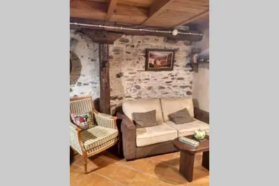 a living room with a couch and a chair at Casa da Penisquela in O Barco de Valdeorras