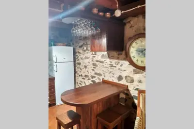 a kitchen with a wooden table and a refrigerator at Casa da Penisquela in O Barco de Valdeorras